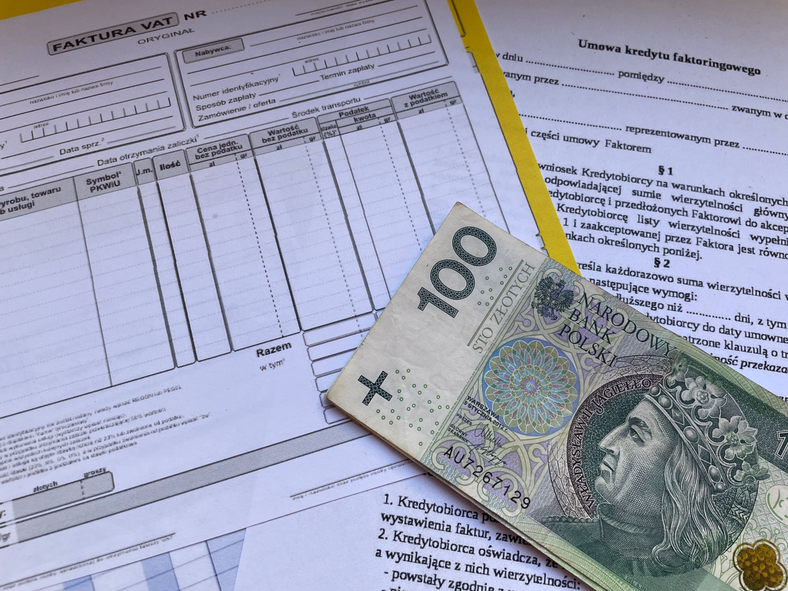 Polish zloty banknotes on top of FAKTURA VAT invoice document — illustrates payment terms, T/T telegraphic transfer, letter of credit, and currency exchange for outdoor gear imports